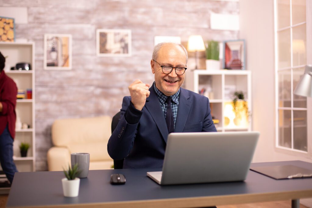 successful elderly person suit working laptop from home his wife is background 1